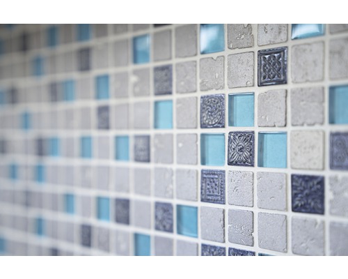 Detailný záber steny so štvorcovými mozaikovými dlaždicami vo vzhľade kameňa, skla a s ornamentmi