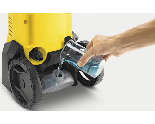 Osoba naleje čistiaci prostriedok do vysokotlakového čističa.