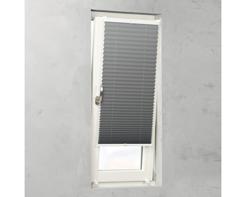 Sivá skladaná roleta na okne na reguláciu svetla.