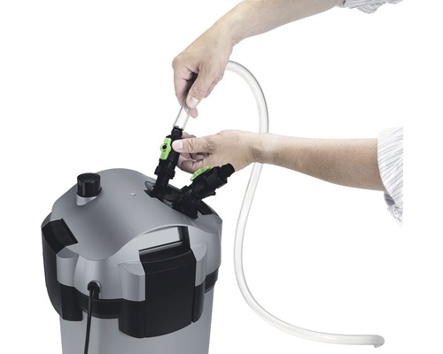 Osoba pripája hadicu k externému filtru pre akváriá.