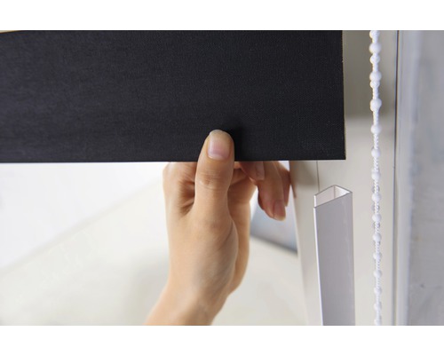 Detailný záber osoby ovládajúcej čiernu roletu s retiazkou