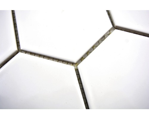Detail bielych hexagonálnych dlaždíc so škárovacou hmotou