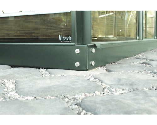 Detailný pohľad na kovový skleník so skrutkami na kamennej dlažbe