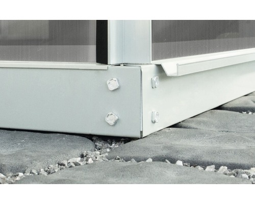 Detail základu skleníka so skrutkami na dlažobných kockách