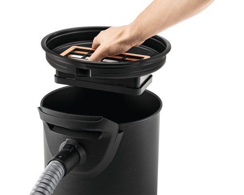 Muž vkladá filter do vysávača.