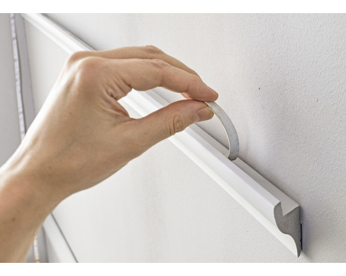 Upevnenie ozdobnej lišty lepiacou páskou na stenu