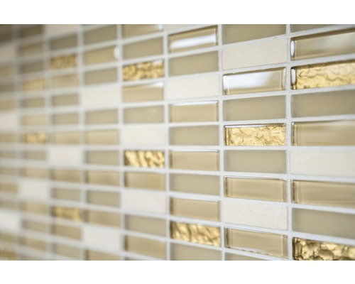 Detail steny s mozaikovými dlaždicami v béžových, zlatých a krémových odtieňoch