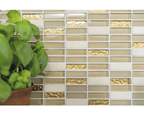 Stena z mozaikových dlaždíc so sklenenými a zlatými akcentmi a rastlina bazalky v kvetináči