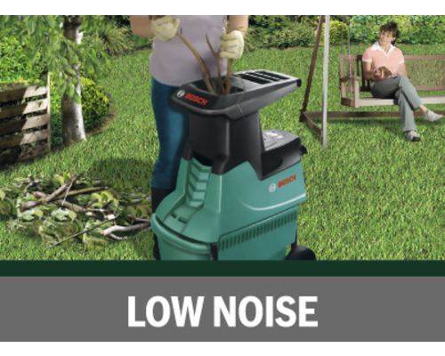 Záhradná scéna s osobou obsluhujúcou drvič, v pozadí osoba na lavičke