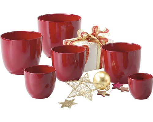 Skupina červených kvetináčov s darčekom a vianočnou dekoráciou