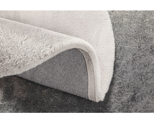 Detailný pohľad na svetlý koberec s textilnou podložkou