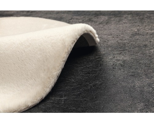 Detail okrúhleho, svetlého koberca s vysokým vlasom