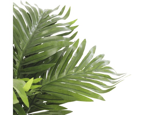 Detail umelej palmy so zelenými listami ako dekorácia