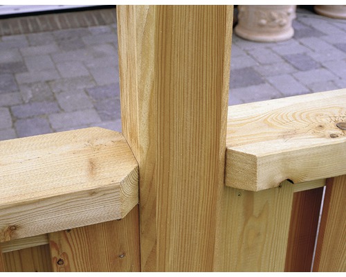 Detail dreveného plota so stĺpikmi a priečkami.