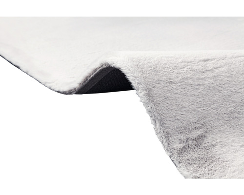 Detailný pohľad na svetlý koberec s vysokým vlasom