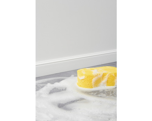 Žltá čistiaca špongia s penou na podlahe