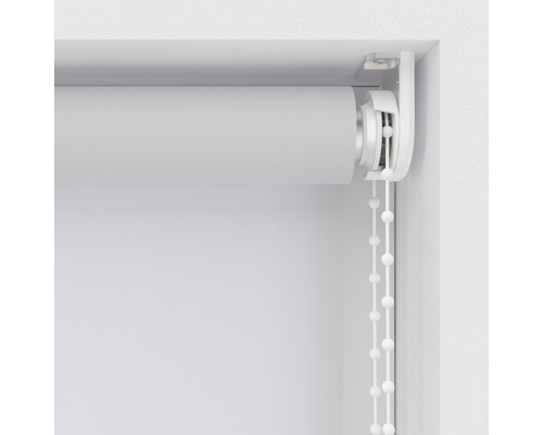 Detailný pohľad na bielu roletu s retiazkovým pohonom pri okne