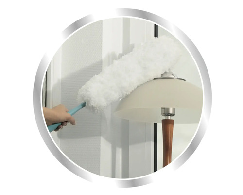 Osoba utiera prach z lampy prachovkou.