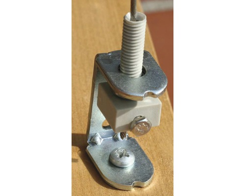 Detailný záber držiaka oceľového lanka so skrutkami a pružinovým prvkom na upevnenie.