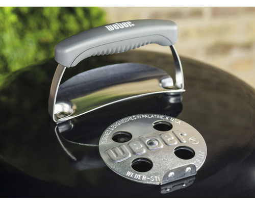 Detailný pohľad na veko grilu Weber s rukoväťou a logom.