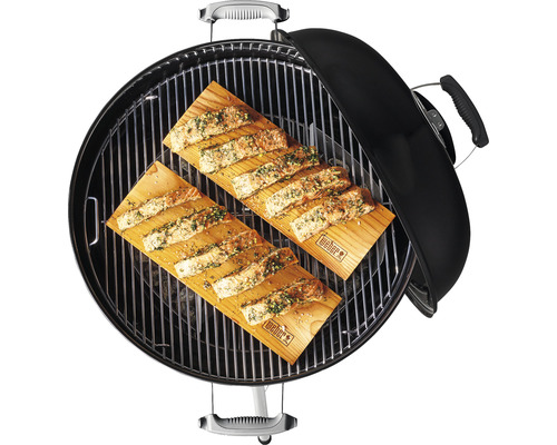 Gril s dvoma drevenými doskami a lososom na grilovanie