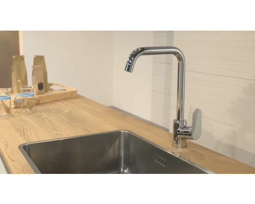 Kuchynská scéna s drezom, batériou a drevenou pracovnou doskou