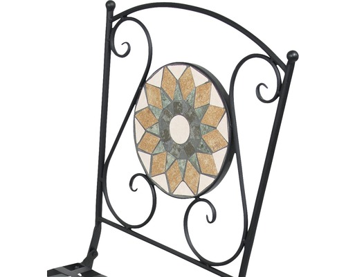 Detail záhradnej stoličky s mozaikovým vzorom v operadle a kovovým rámom.