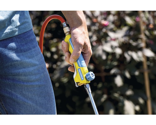 Osoba drží v ruke hubič buriny značky Gloria.