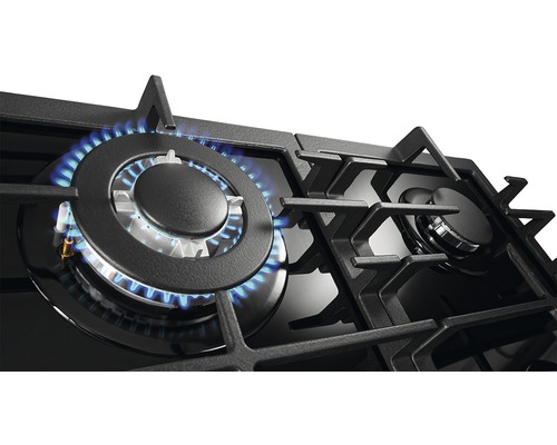 Detail plynového varného panela s horiacim plameňom