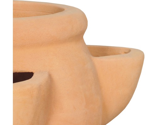 Detailný pohľad na terakotovú vázu na rastliny s niekoľkými otvormi na rastliny.