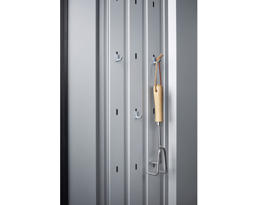 Držiak na náradie so záhradným náradím na sivej stene