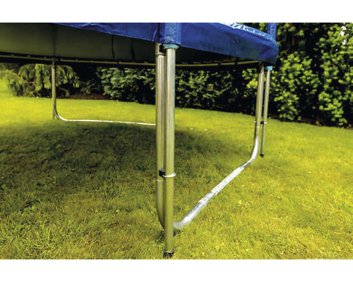 Detailný pohľad na záhradnú trampolínu s oceľovým rámom a modrým krytom okraja na trávniku