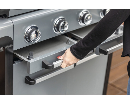 Detail plynového grilu s otvorenou zásuvkou, ovládaný rukou