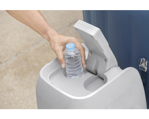 Osoba vkladá fľašu s vodou do odpadkového koša.