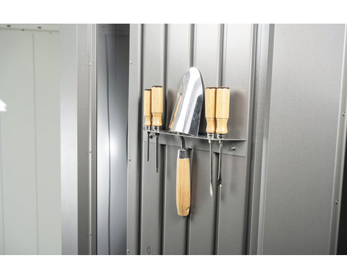 Záhradné náradie zavesené na kovovej stene