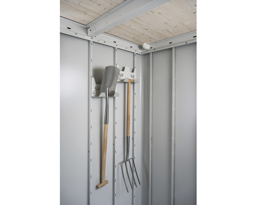Interiér záhradného domčeka s lopatou, vidlami a držiakom na náradie