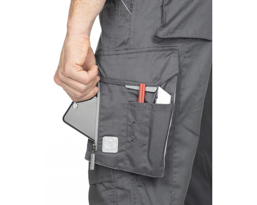 Detailný záber pracovných nohavíc s vreckom, v ktorom je mobilný telefón a pero