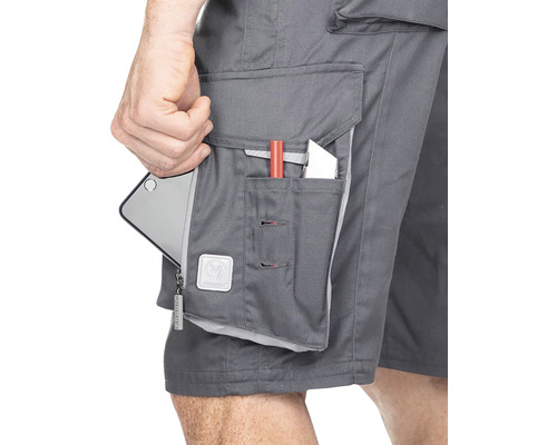 Detailný záber sivých pracovných šortiek s niekoľkými vreckami, v ktorých je smartfón, pero a nôž.