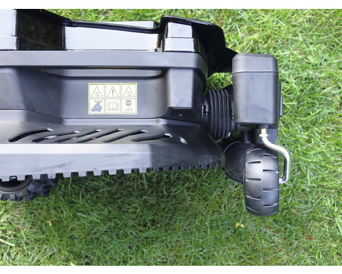 Detailný pohľad na kosačku na trávu s výstražnými štítkami o bezpečnostných pokynoch