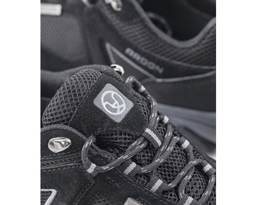 Detailný záber na čiernu trekovú obuv so šnúrkami a logom.