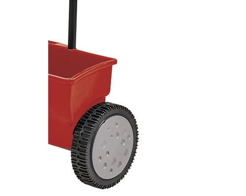 Detailný pohľad na posypový vozík s červenou nádobou a čiernou rukoväťou