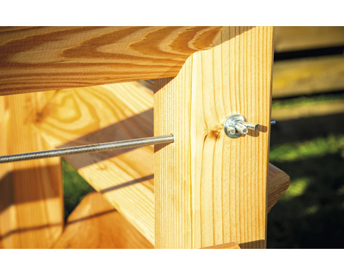 Detail drevenej konštrukcie so závitovou tyčou a skrutkami na upevnenie.