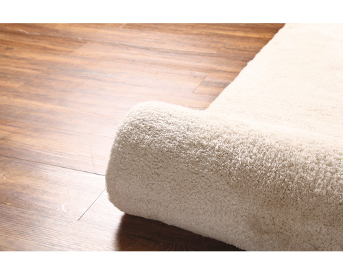 Detailný pohľad na zrolovaný koberec na drevenej podlahe