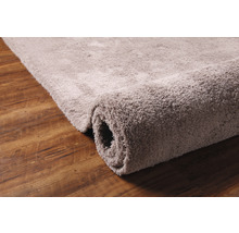 Zrolovaný koberec na drevenej podlahe