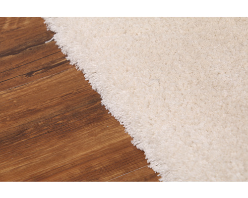 Detailný pohľad na svetlý koberec na drevenej podlahe