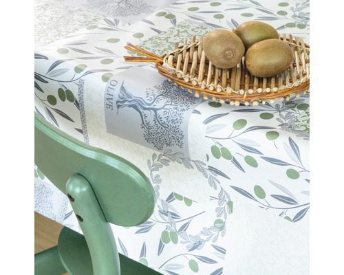 Obrus s olivovým vzorom a kiwi v košíku na stole