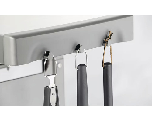 Detailný záber držiaka na grilovacie náčinie s grilovacími kliešťami a obracačkou