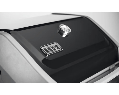 Detailný pohľad na veko grilu Weber s teplomerom a logom Weber