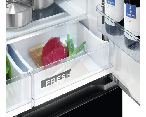 Detailný záber chladničky s priehradkou na čerstvé potraviny obsahujúcou mäso a zeleninu