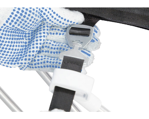 Detailný záber ruky s pracovnou rukavicou, ktorá pripevňuje uzáver k upínaciemu popruhu.